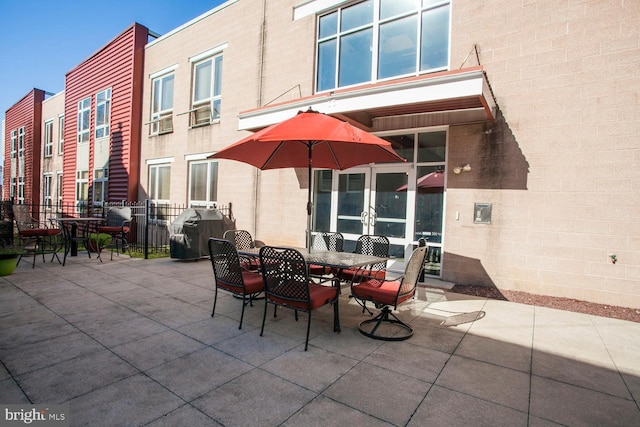 view of patio featuring outdoor dining area, a grill, and french doors