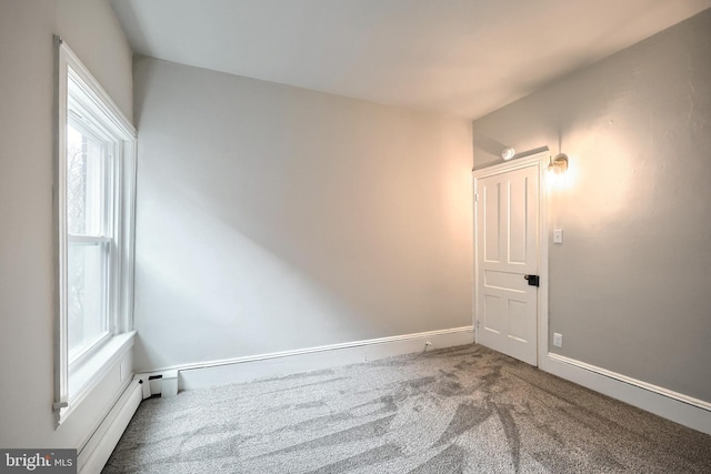 spare room with a baseboard radiator, baseboards, carpet, and a healthy amount of sunlight