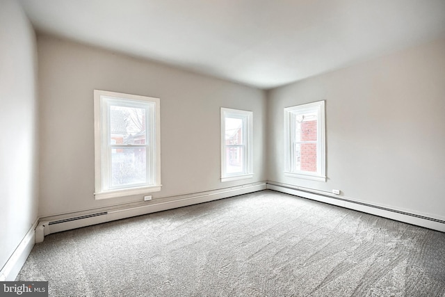 empty room featuring baseboard heating and carpet floors