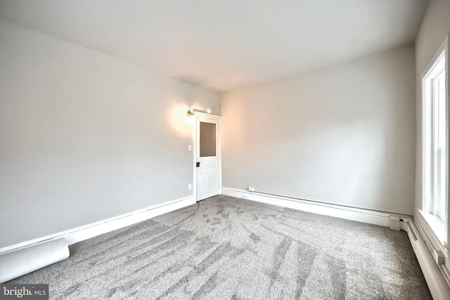 spare room with a baseboard radiator, baseboards, and carpet floors