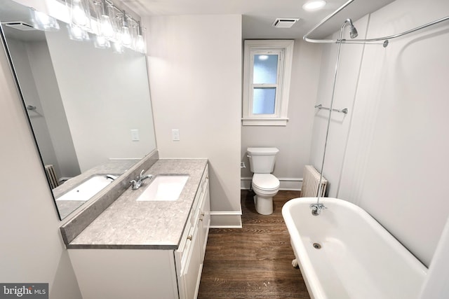 full bath with visible vents, wood finished floors, radiator heating unit, a soaking tub, and vanity