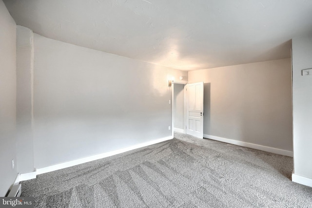 carpeted spare room with baseboards