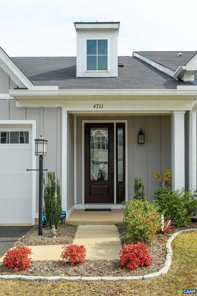 entrance to property featuring a porch, a garage, and board and batten siding