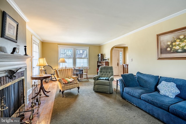 living area with baseboards, a fireplace, arched walkways, and ornamental molding