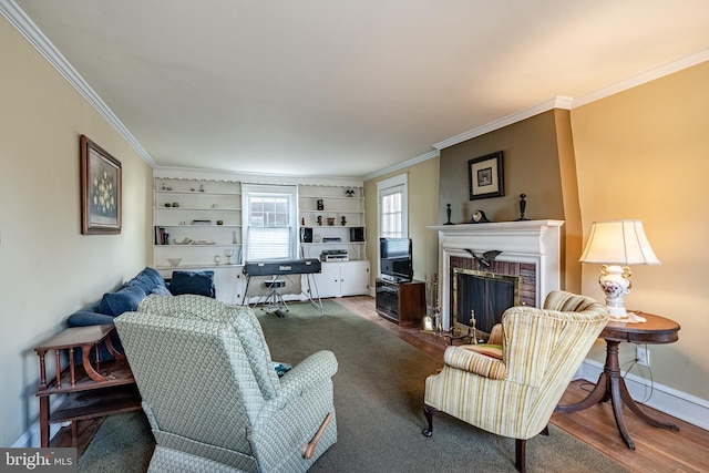 living area featuring crown molding, wood finished floors, a fireplace, and baseboards