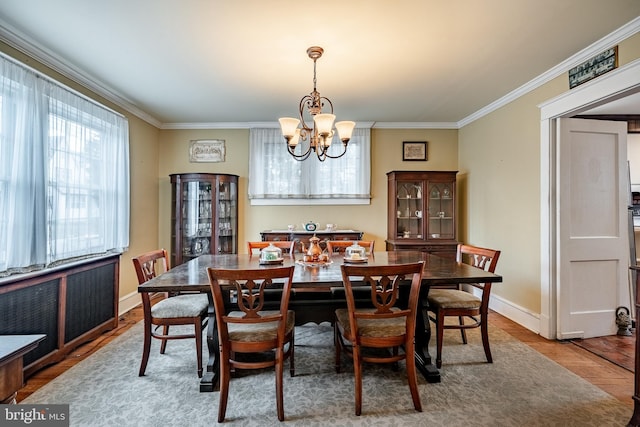 dining area featuring baseboards, a notable chandelier, and ornamental molding