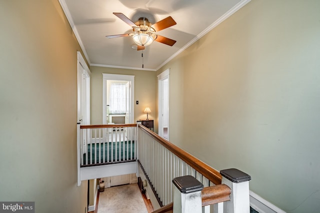 stairway featuring ceiling fan, baseboards, ornamental molding, and carpet flooring