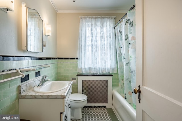 bathroom with radiator, a healthy amount of sunlight, vanity, and toilet