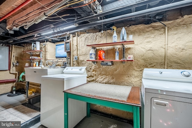 washroom with washer and clothes dryer, laundry area, electric panel, and a sink