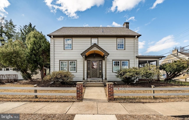 view of front of house with a shingled roof, fence, and a chimney