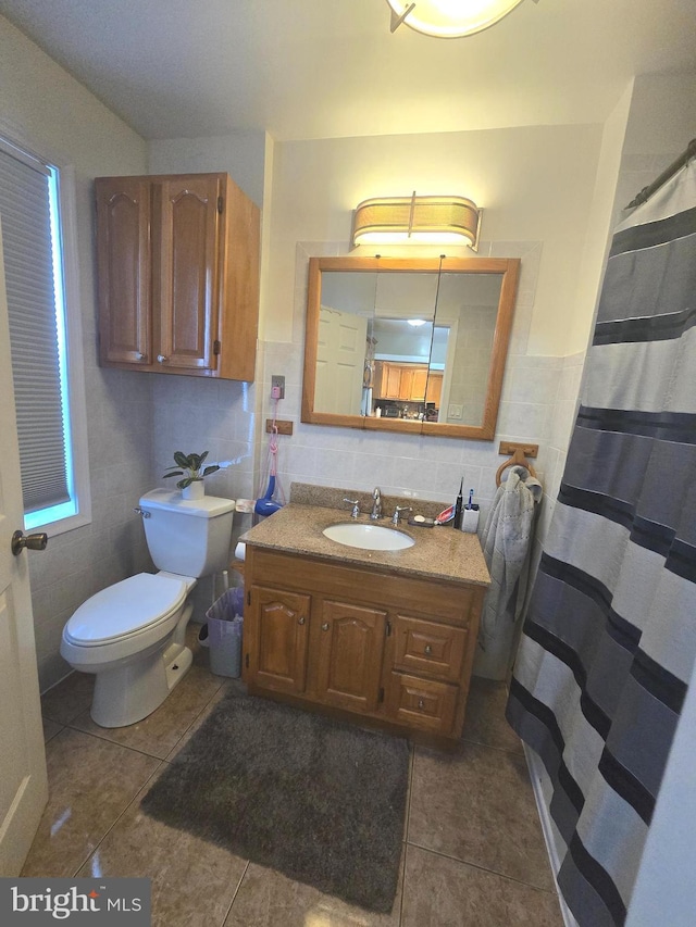 bathroom featuring tile walls, curtained shower, toilet, vanity, and tile patterned flooring