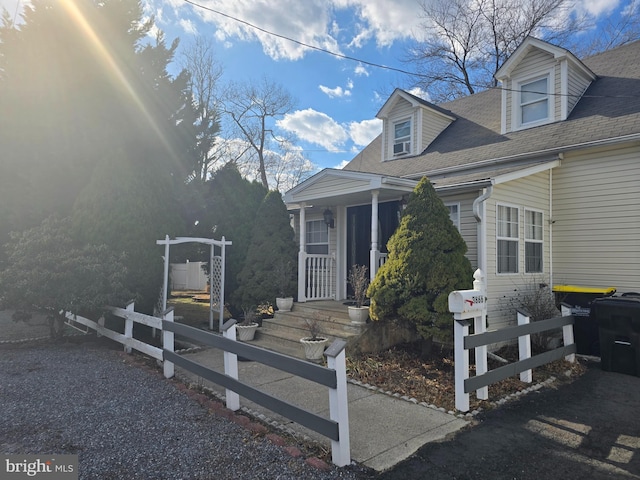 exterior space featuring roof with shingles and fence