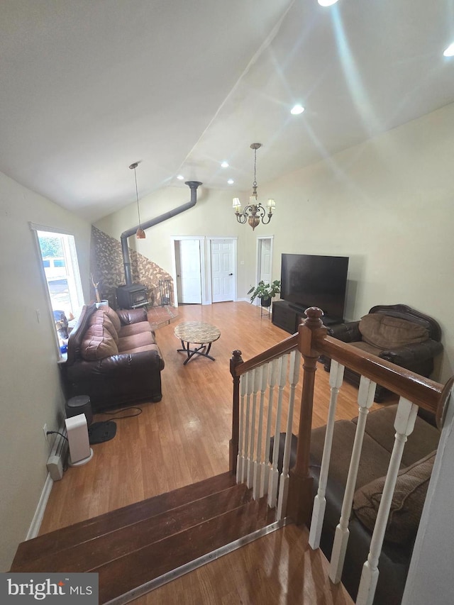 living room with lofted ceiling, recessed lighting, an inviting chandelier, wood finished floors, and stairs