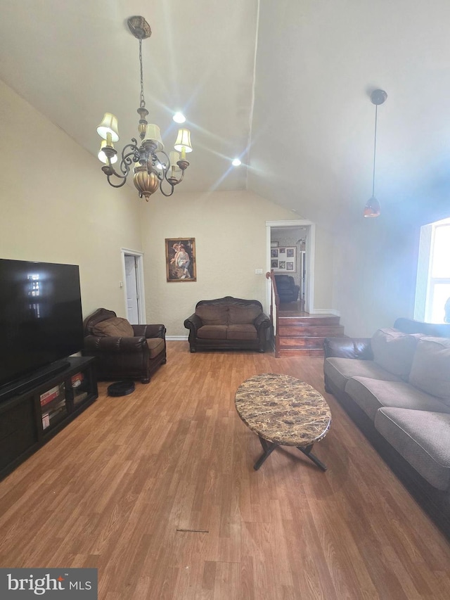 living area featuring vaulted ceiling, wood finished floors, and a chandelier