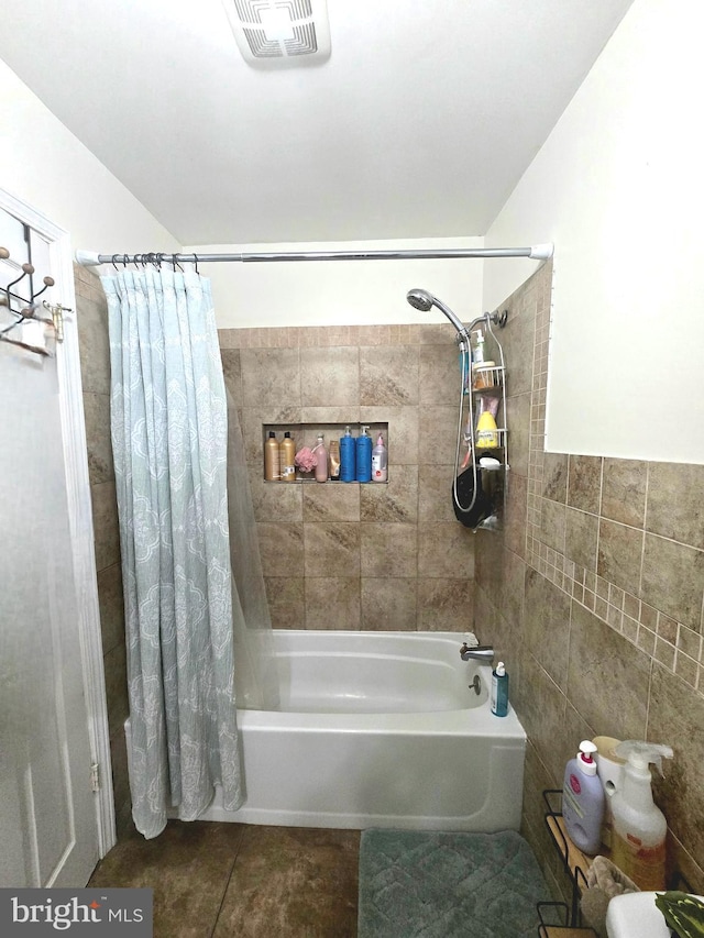 full bath featuring tile patterned flooring, visible vents, shower / tub combo with curtain, and tile walls