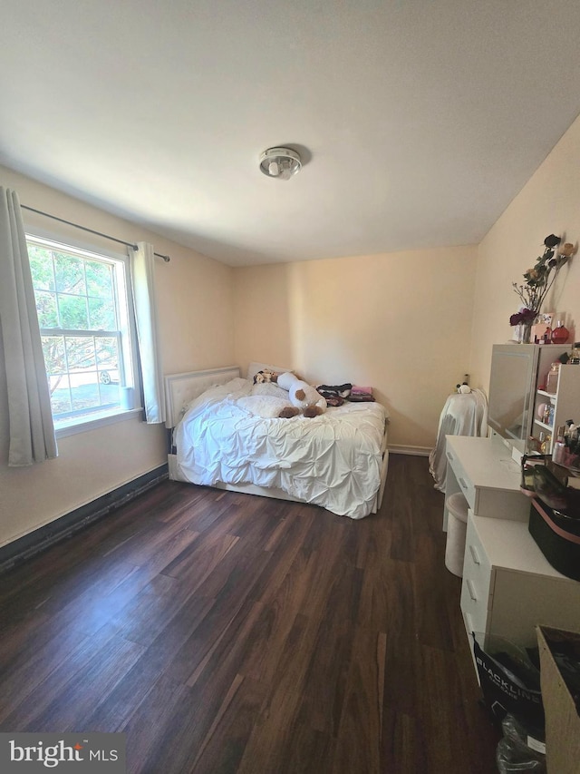 bedroom featuring baseboards and dark wood-style flooring