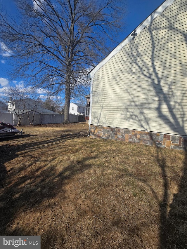 view of side of home with crawl space and fence