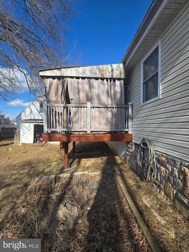 view of home's exterior featuring an outbuilding and a wooden deck