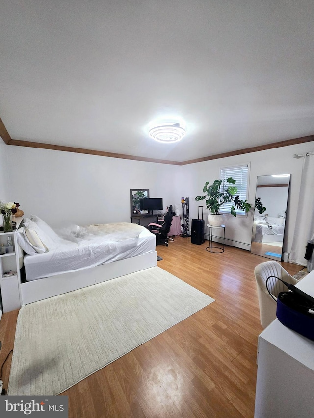 bedroom featuring crown molding and wood finished floors