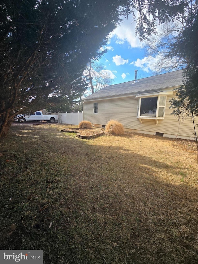 view of home's exterior with a yard and fence