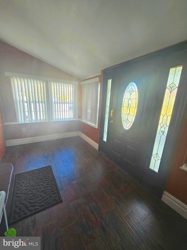 foyer featuring lofted ceiling, wood finish floors, and baseboards