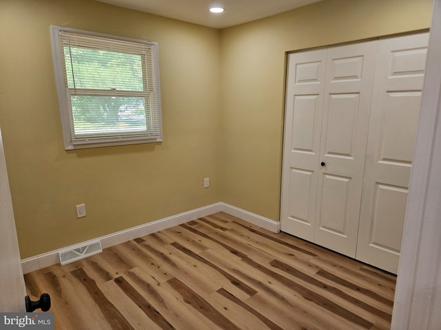 unfurnished bedroom with recessed lighting, visible vents, baseboards, a closet, and light wood-type flooring