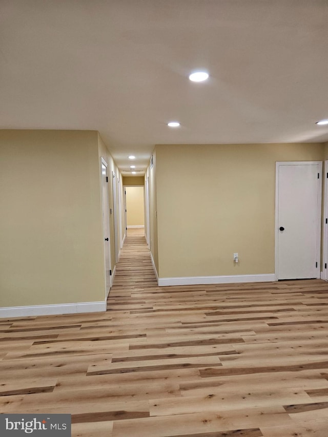 empty room with light wood-style flooring, baseboards, and recessed lighting