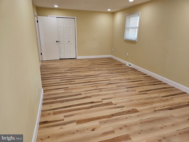 empty room featuring recessed lighting, baseboards, and wood finished floors