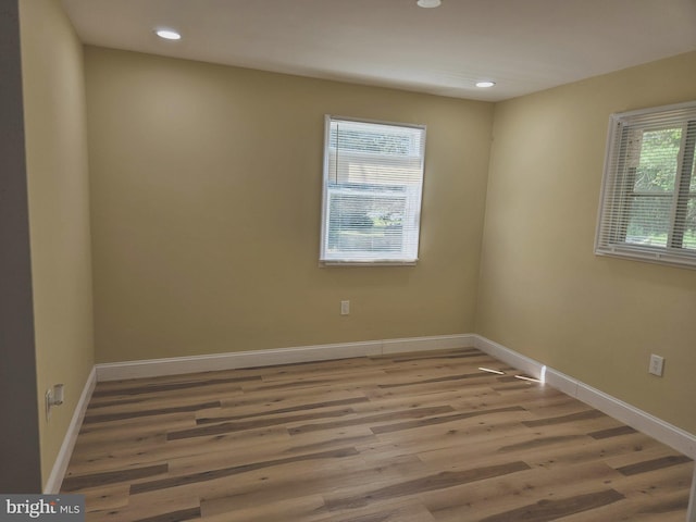 unfurnished room with recessed lighting, wood finished floors, and baseboards