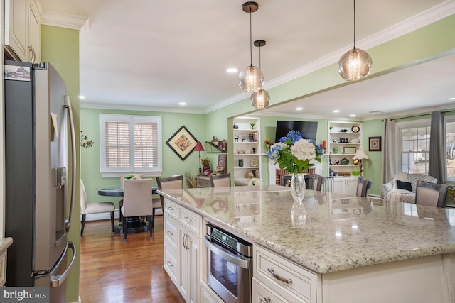 kitchen featuring appliances with stainless steel finishes, open floor plan, dark wood-style flooring, and crown molding