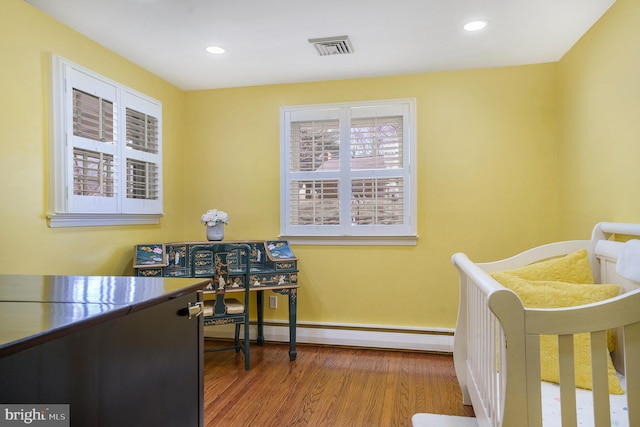 bedroom with visible vents, recessed lighting, a baseboard radiator, and wood finished floors