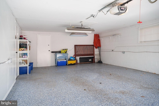 garage with concrete block wall and a garage door opener