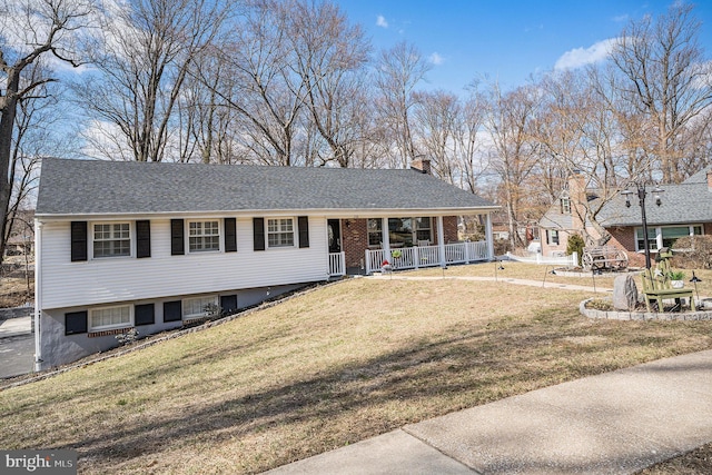 view of front of home featuring a front yard, covered porch, a shingled roof, a chimney, and brick siding