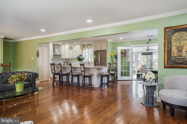 living room with dark wood-type flooring, crown molding, recessed lighting, and a healthy amount of sunlight