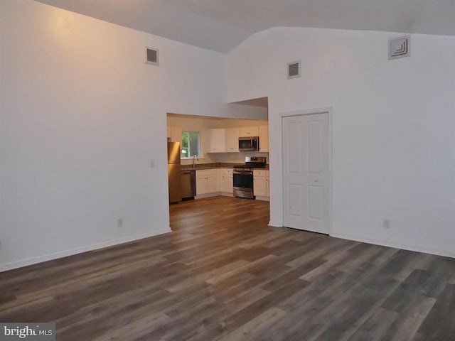 unfurnished living room featuring dark wood-style flooring, visible vents, and baseboards