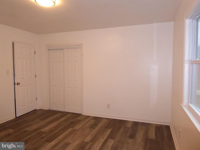 interior space featuring baseboards and dark wood-type flooring