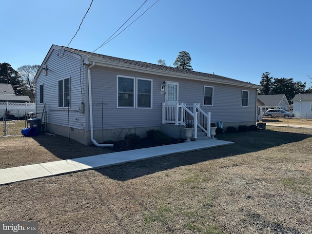 view of front of house with a front yard, crawl space, and fence