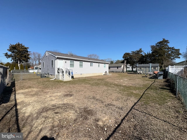 rear view of property with entry steps, crawl space, a fenced backyard, and central AC