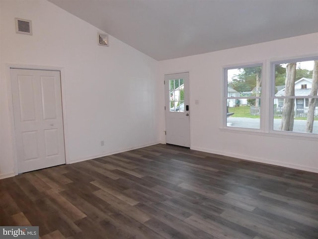 spare room with lofted ceiling, dark wood-type flooring, visible vents, and baseboards