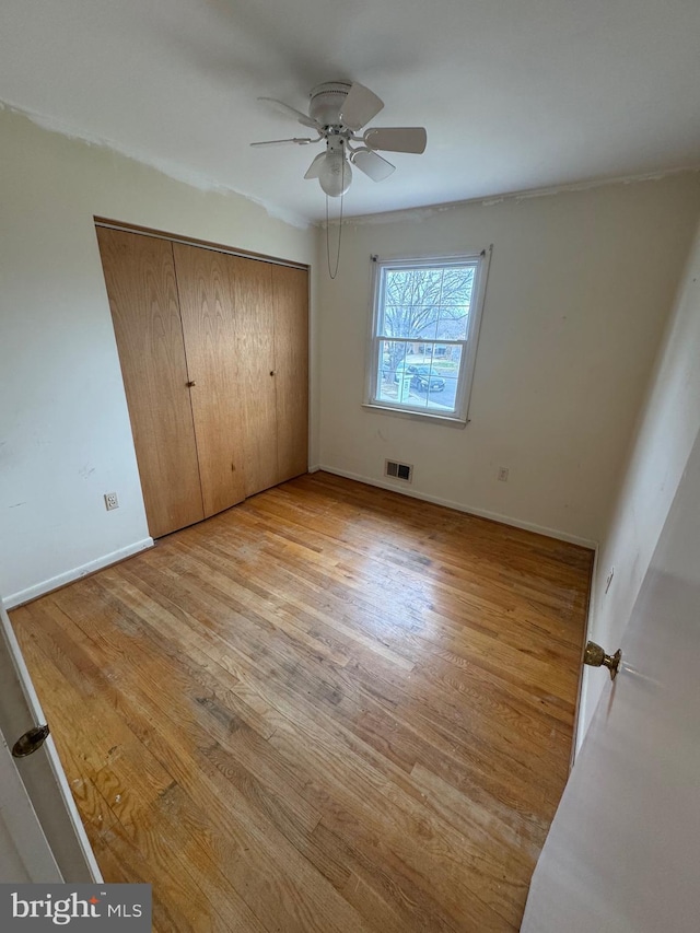 unfurnished bedroom featuring a closet, visible vents, light wood-type flooring, and baseboards