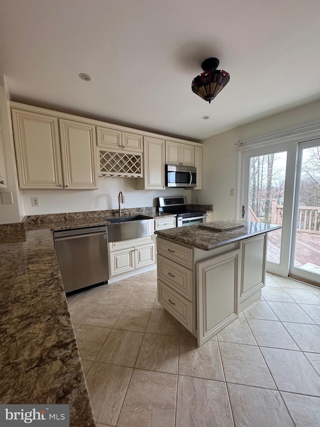 kitchen with a sink, stainless steel appliances, and cream cabinetry