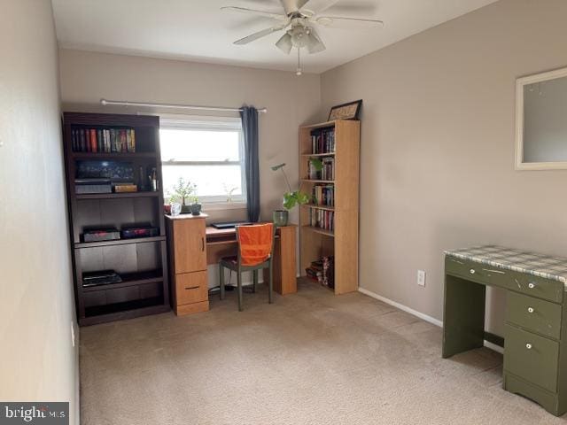 office space with baseboards, light carpet, and a ceiling fan