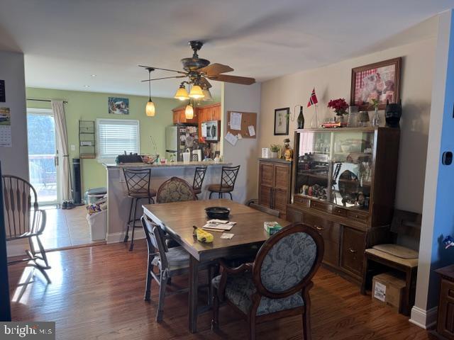 dining room with wood finished floors, baseboards, and ceiling fan