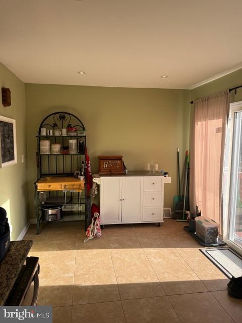 interior space featuring light tile patterned floors, a healthy amount of sunlight, and baseboards