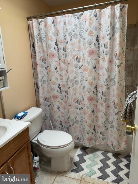 bathroom with toilet, vanity, and a shower with curtain