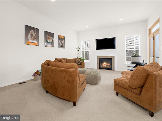 carpeted living room featuring a glass covered fireplace, recessed lighting, visible vents, and baseboards