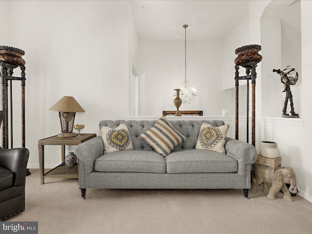 living area featuring baseboards, carpet floors, and an inviting chandelier