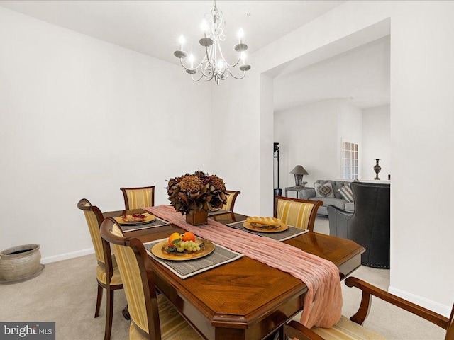 dining room featuring an inviting chandelier, baseboards, and light carpet