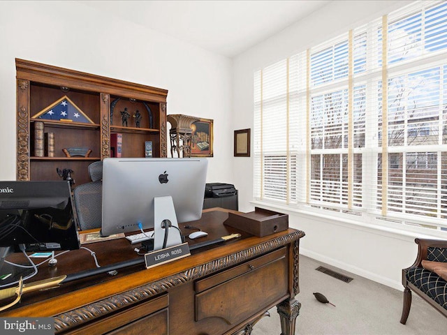 carpeted office featuring visible vents and baseboards