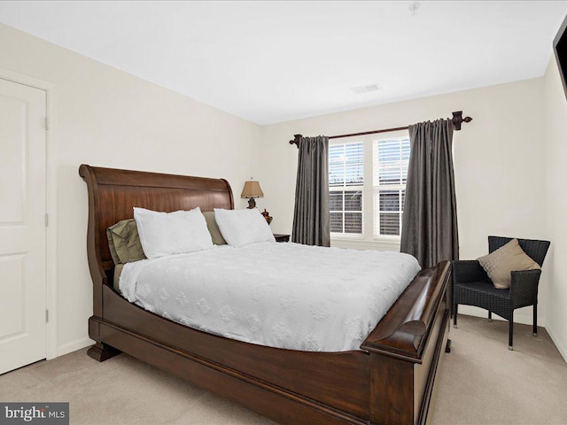 bedroom featuring visible vents, light carpet, and baseboards